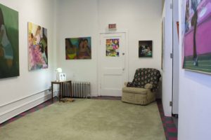 Photo Of Gallery, Artwork With Recliner And Knit Blanket On Green Rug