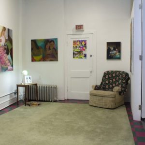 Photo Of Gallery, Artwork With Recliner And Knit Blanket On Green Rug